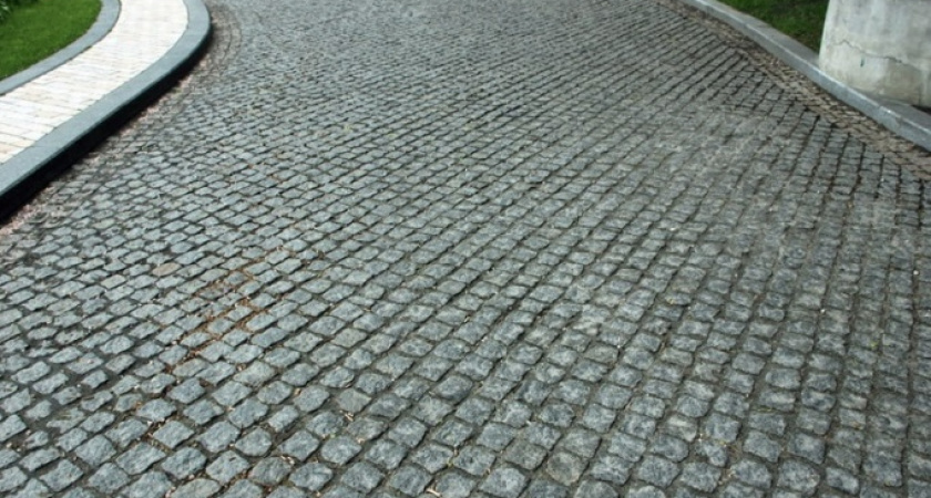 Рабочий выковыривает брусчатку и увозит к себе домой